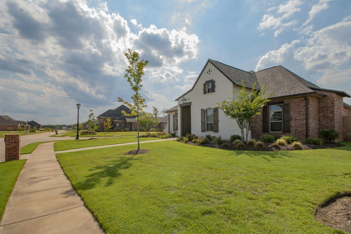 A brick and white-painted home on a corner lot in a newer subdivision