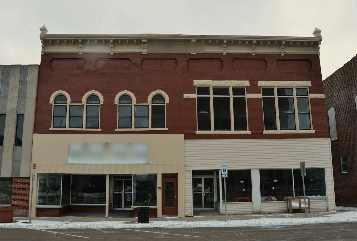 Red-brick storefronts with arched upper windows on a small-town main street